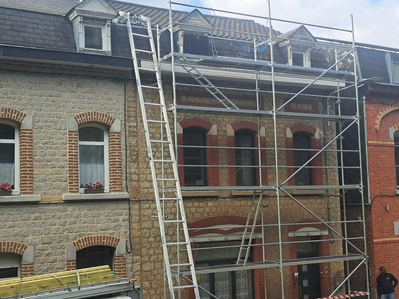 Échafaudage devant une façade en pierre avec lucarnes en cours de restauration, Dinant