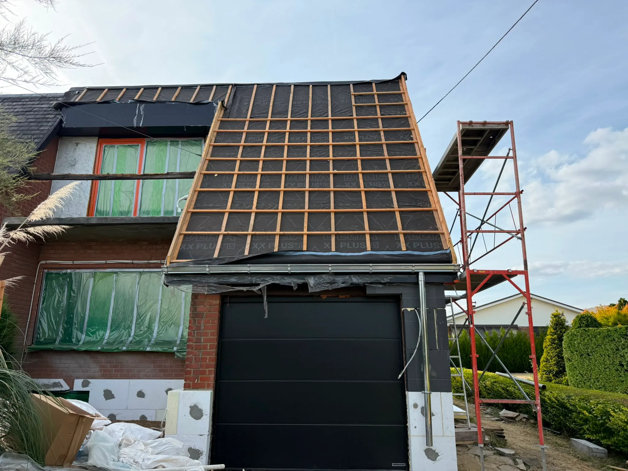 Écran de sous-toiture et liteaux en bois posés sur une maison en briques en rénovation, Namur