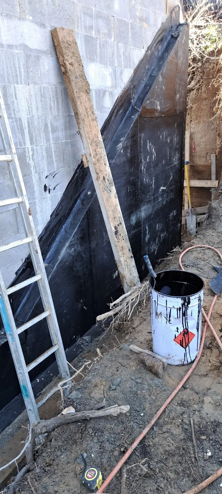 Mur de fondation en cours d’enduction à la membrane bitumineuse, Andenne