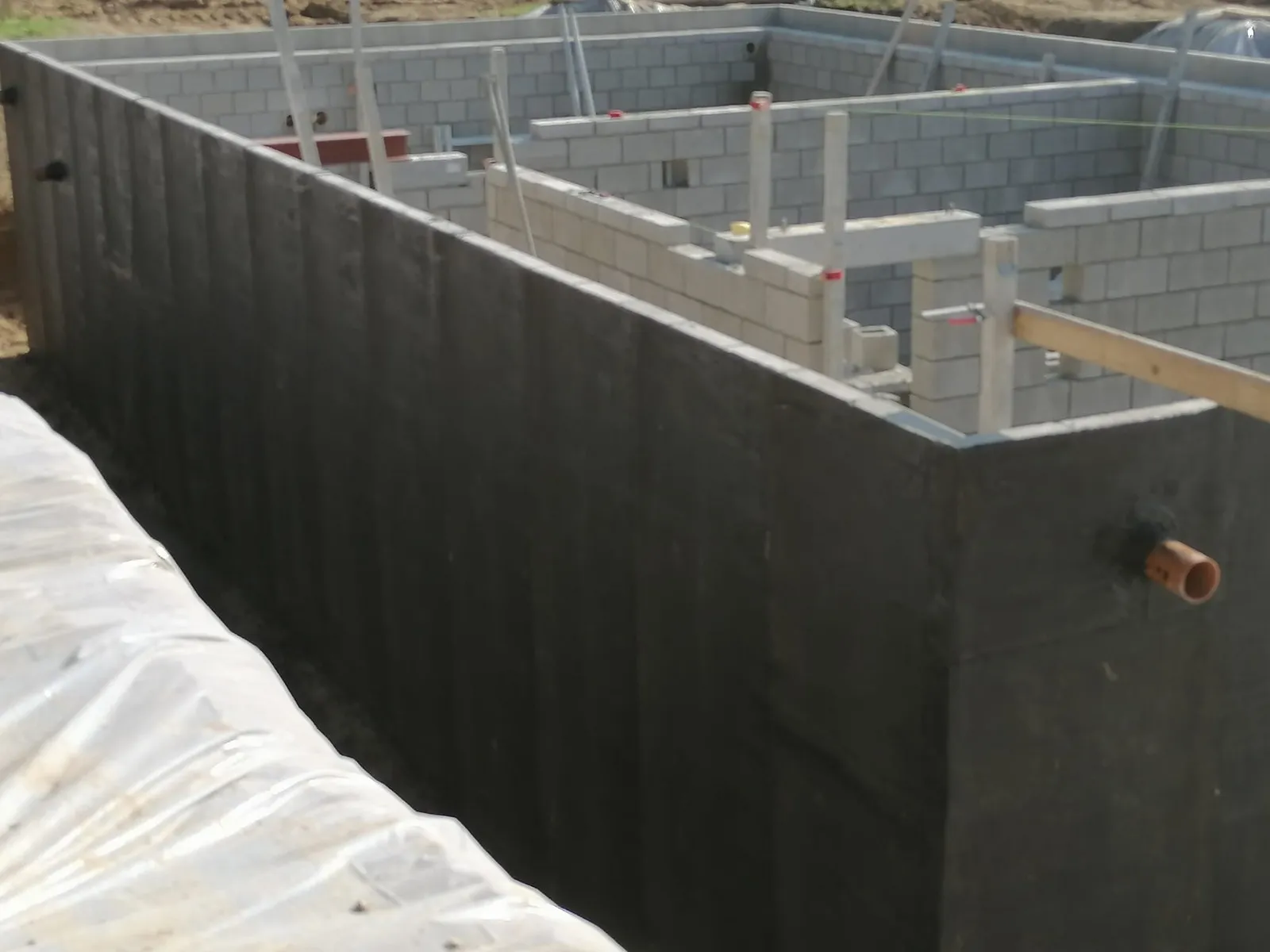 Mur de fondation en blocs béton recouvert d’une membrane d’étanchéité bitumineuse, chantier Andenne