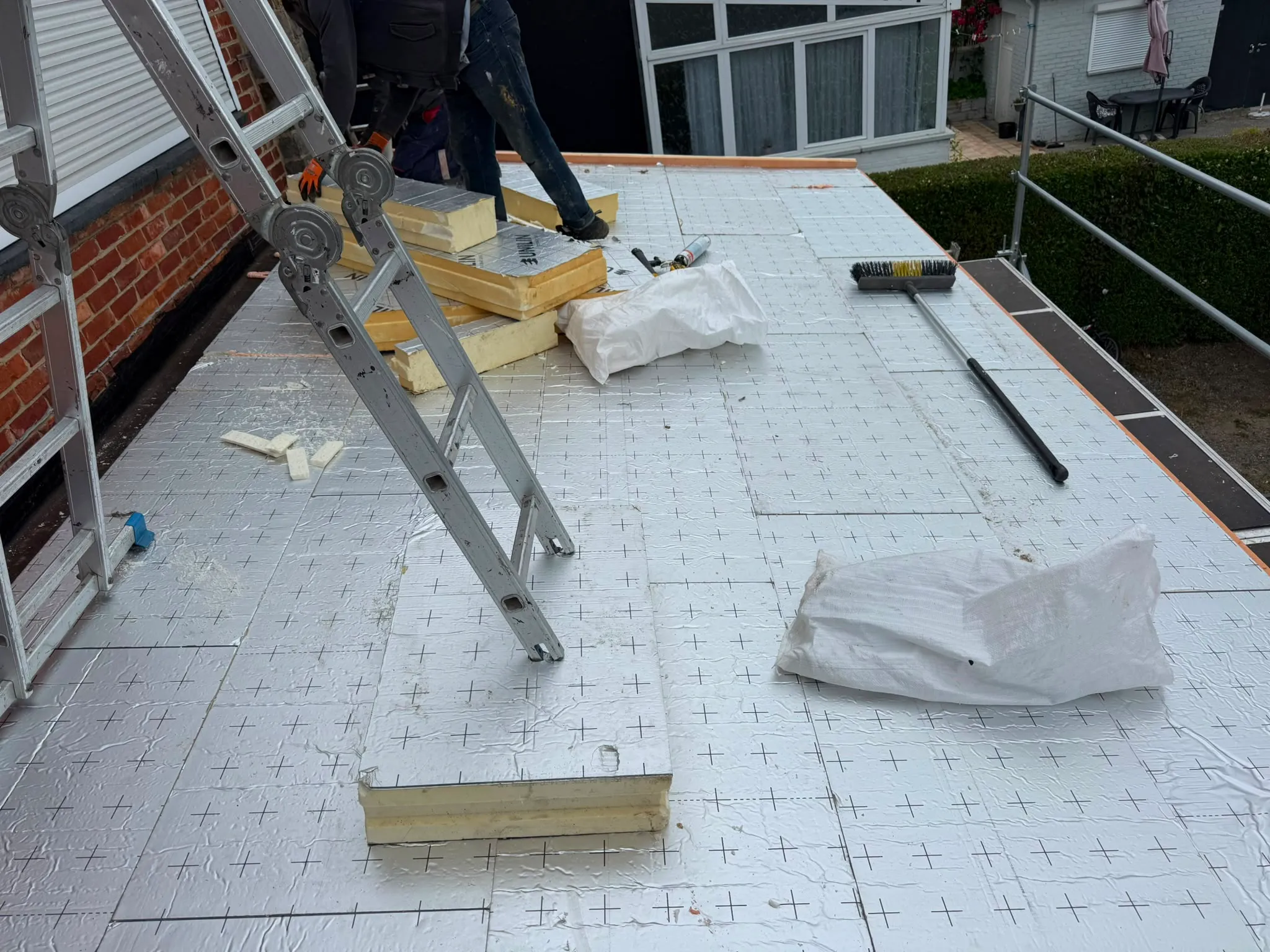 Panneaux isolants à parement aluminium posés sur une toiture plate avec outillage, Namur