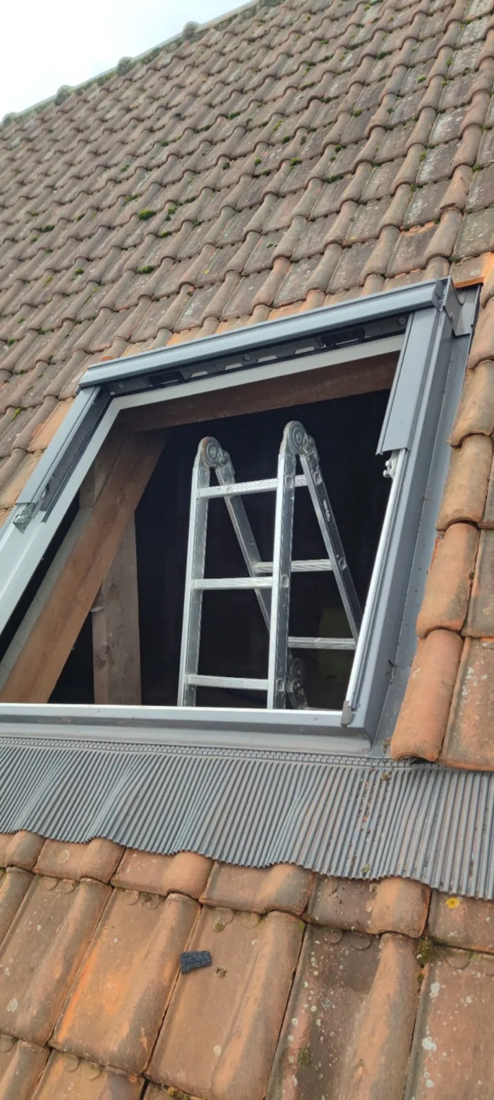 Fenêtre de toit neuve avec habillage aluminium sur une toiture en tuiles moussues, Sambreville