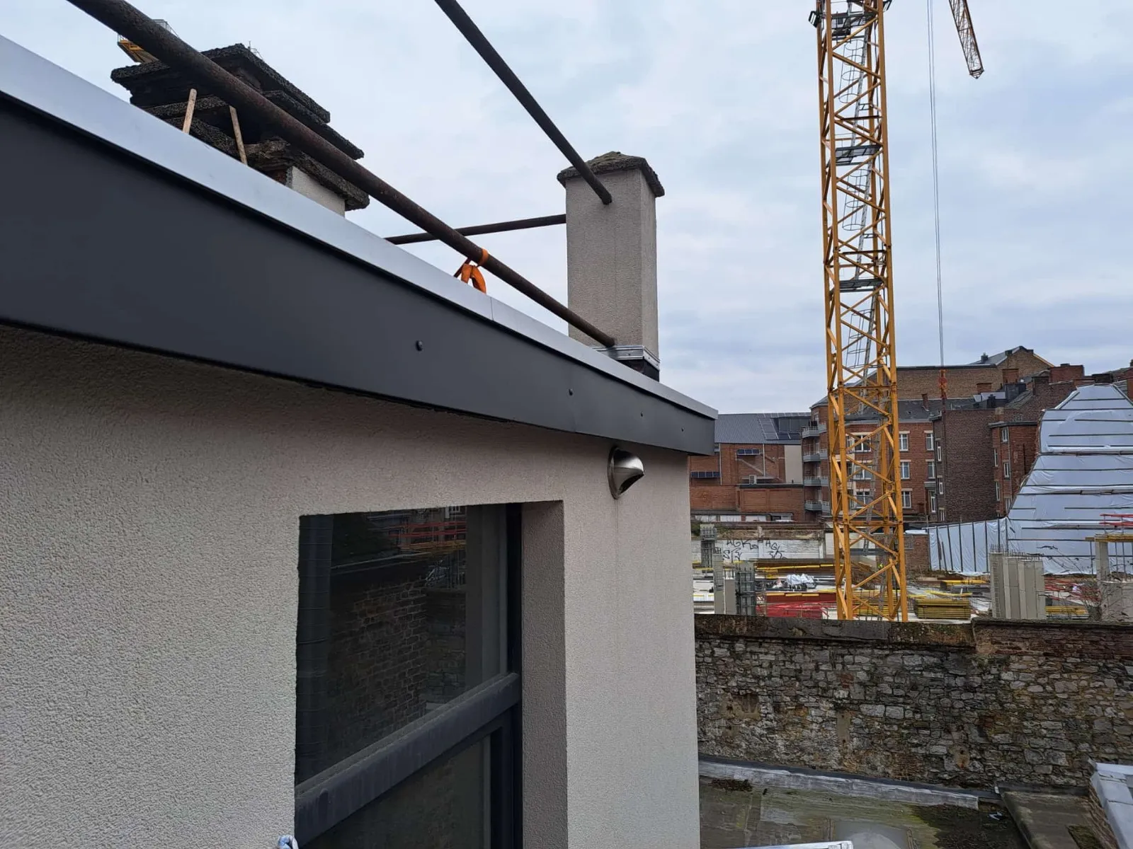 Bandeau de rive en zinc noir neuf ceinturant une souche de cheminée, Namur