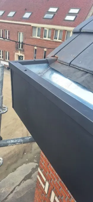 Gouttière en zinc anthracite neuve à l’angle d’un pan de toiture en ardoises, Charleroi