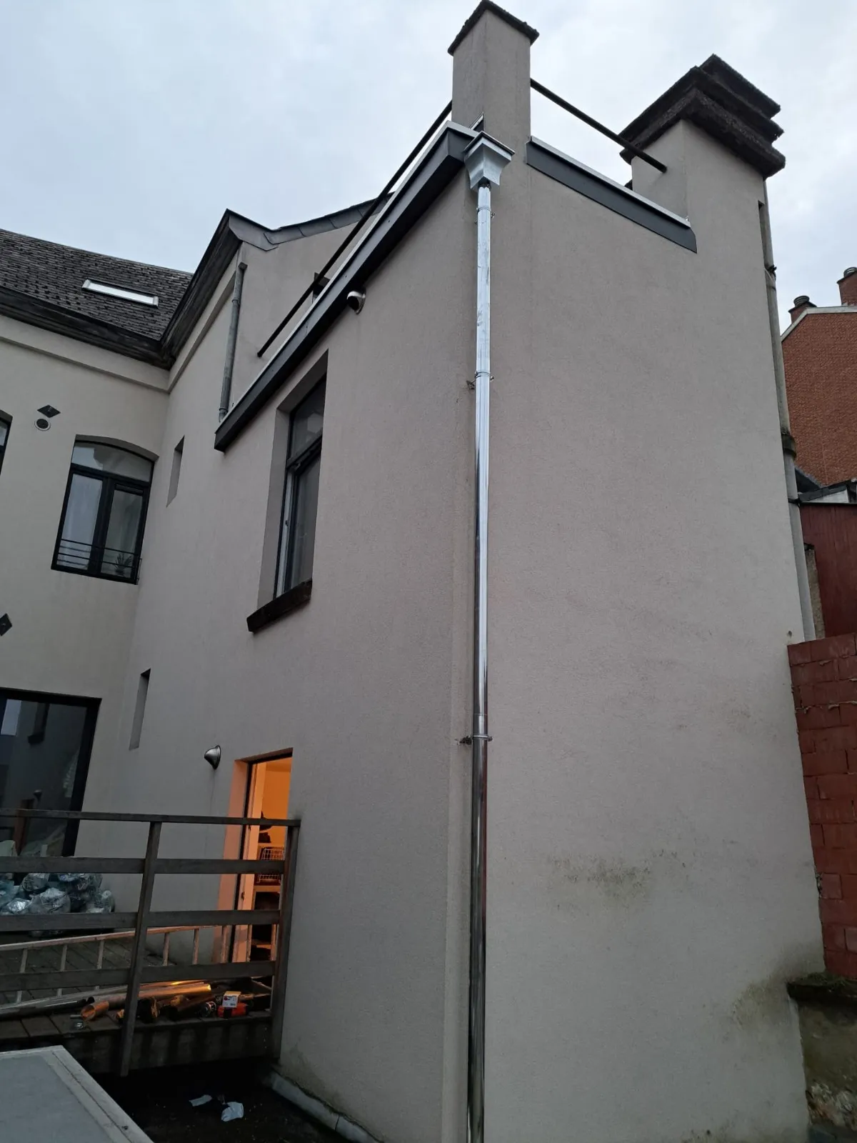 Vue d’ensemble arrière d’un immeuble avec gouttières et descentes en zinc neuves, Namur