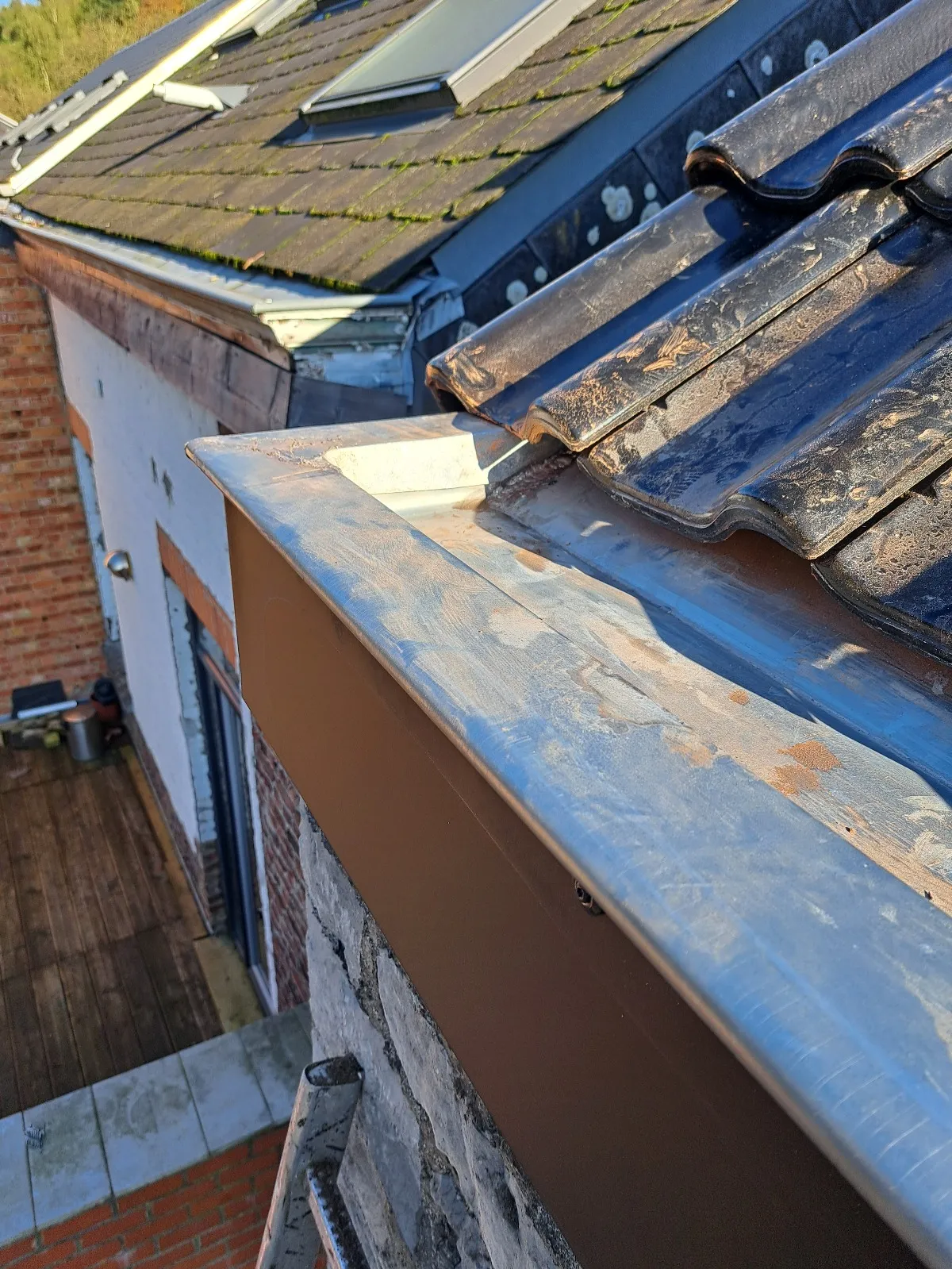 Noue en zinc entre une toiture en tuiles noires et une toiture mitoyenne en ardoises, Jambes